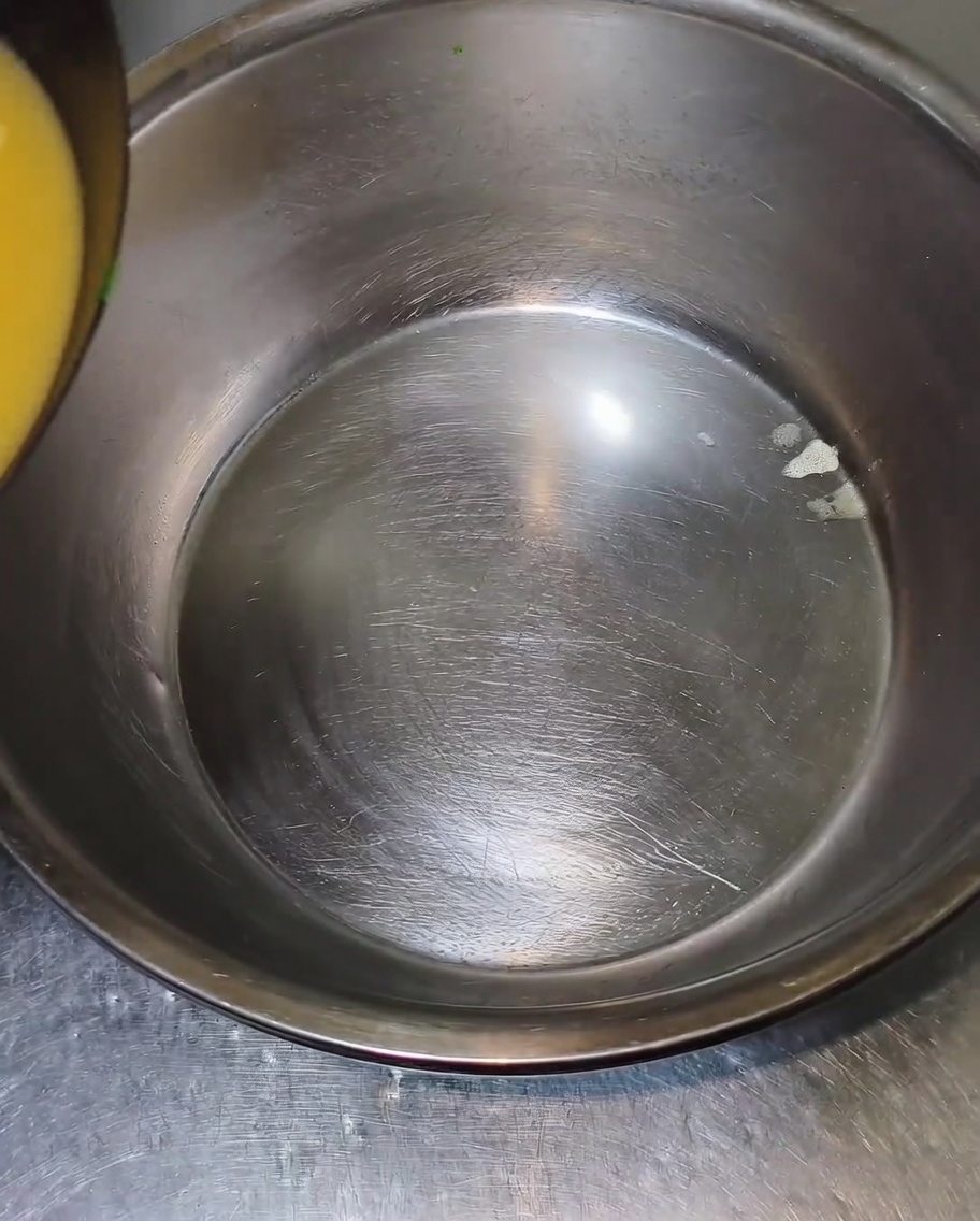Brodo e pollo versati in una ciotola capiente.