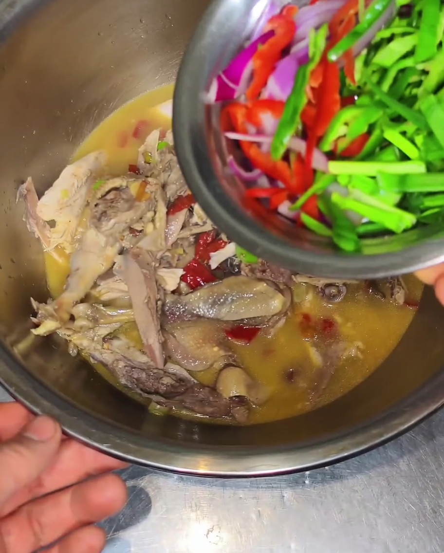 Verdure affettate aggiunte al composto di pollo.