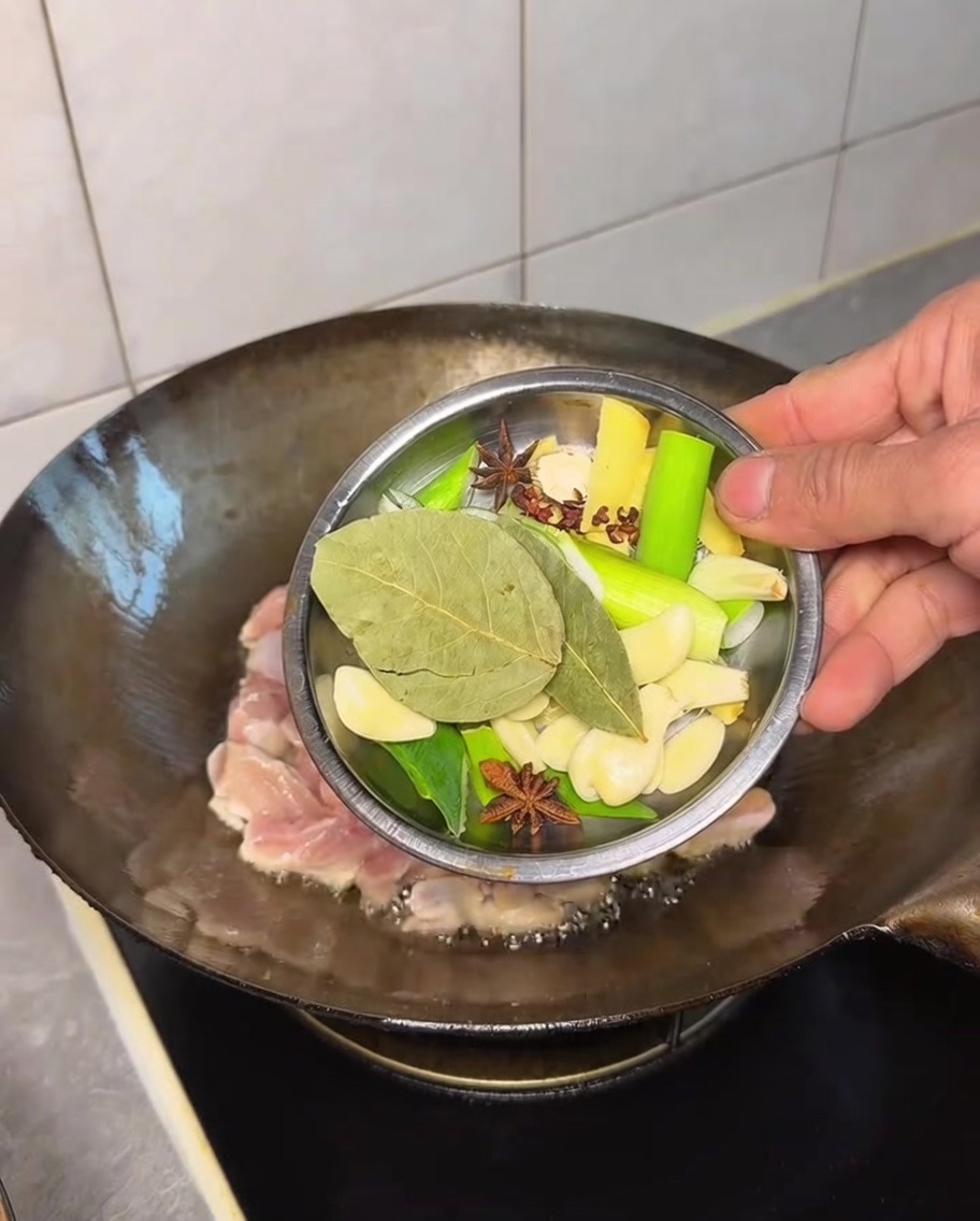 Un mix di aromi interi aggiunti al pollo nel wok.