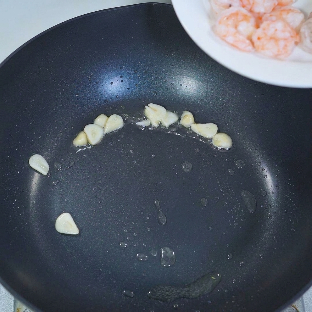 Gamberi precotti aggiunti in padella con laglio saltato.