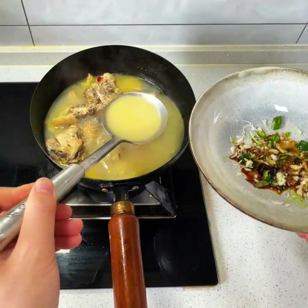 Versare un mestolo di brodo di pollo caldo da un wok in una ciotola di condimenti.
