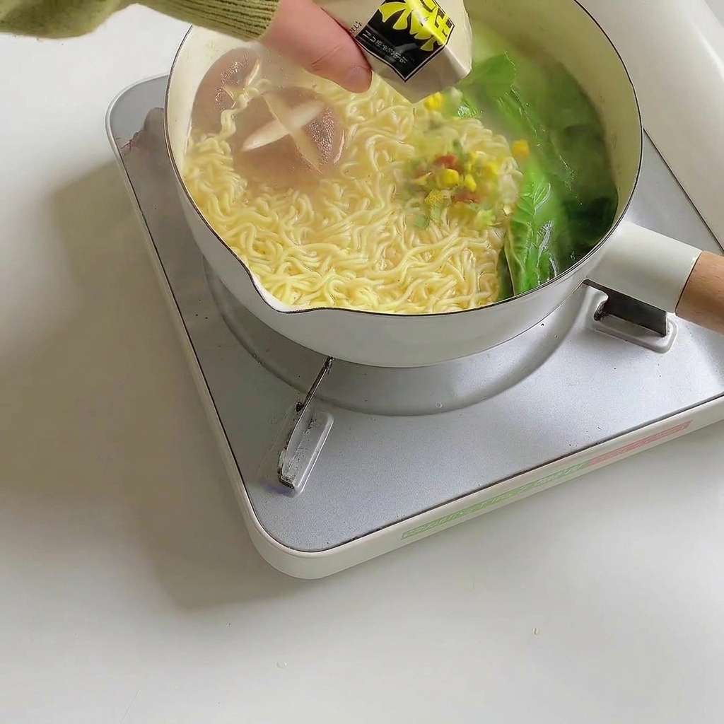 Guarnizioni del ramen spolverate sulla zuppa di noodles pronta.
