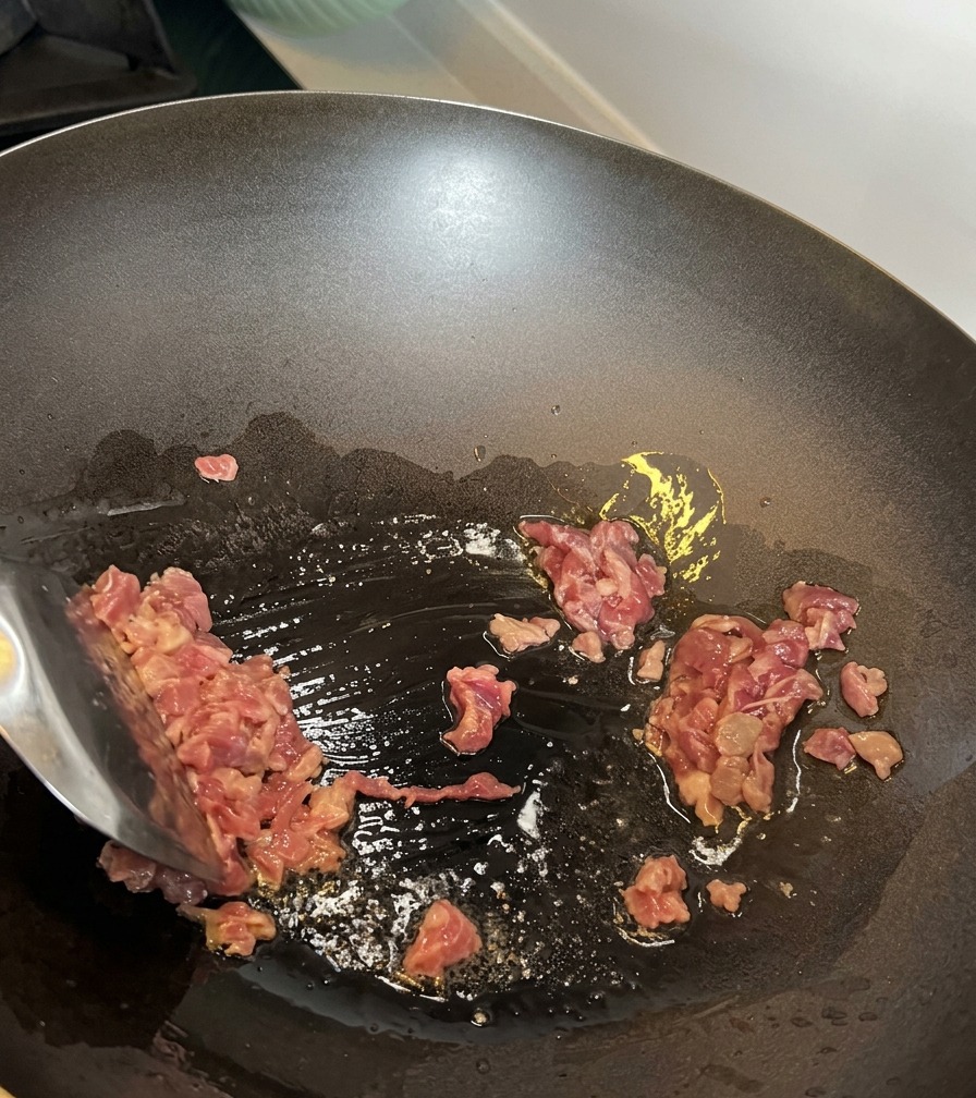 Carne a cubetti rosolata in un wok caldo.