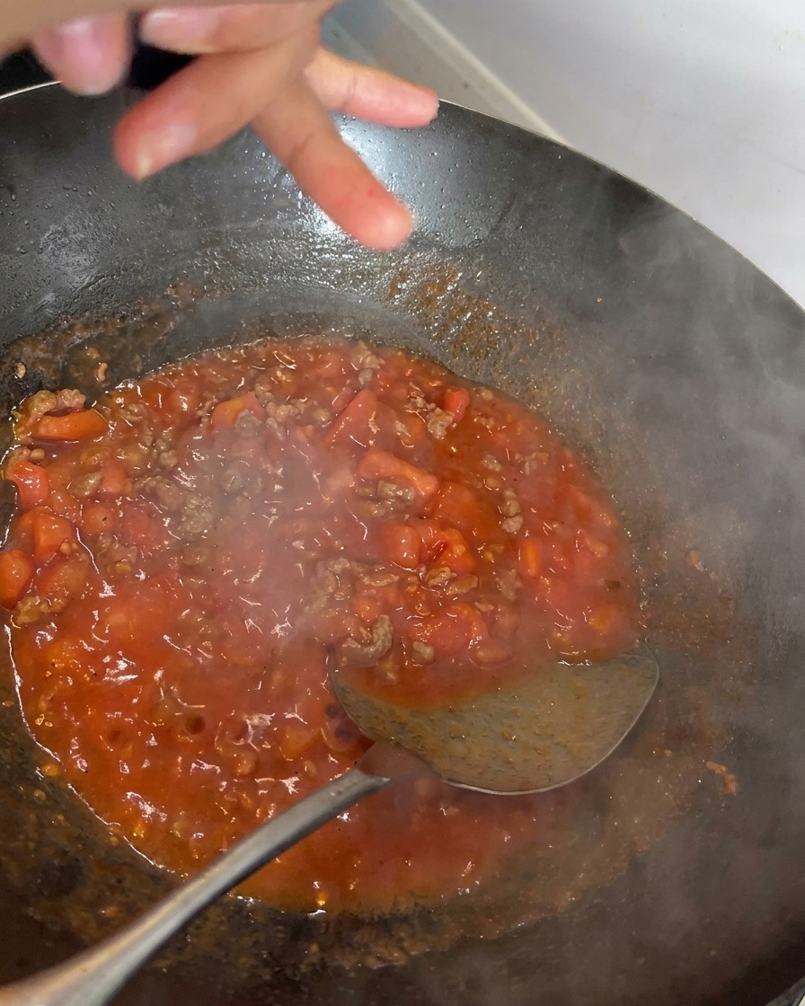 Pepe nero macinato fresco su un sugo rosso intenso.
