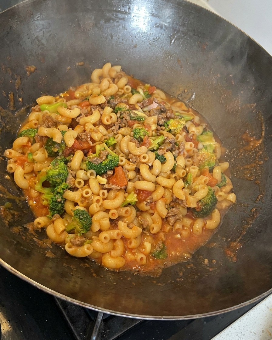 Pasta e sugo mescolati insieme nel wok.