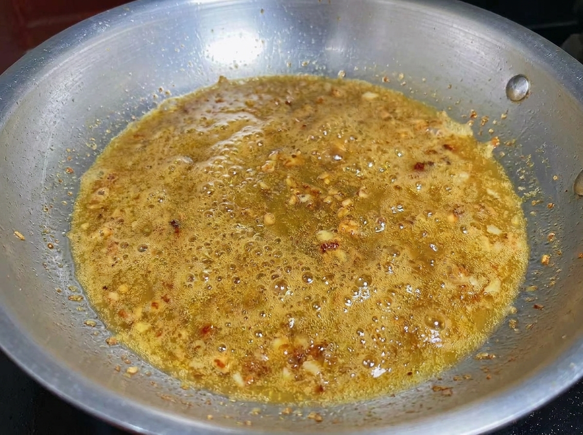Aglio tritato e gamberi in cottura nellolio aromatizzato.