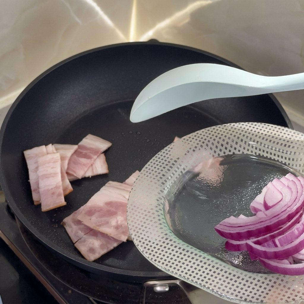 Pezzetti di bacon che sfrigolano in una padella antiaderente calda.