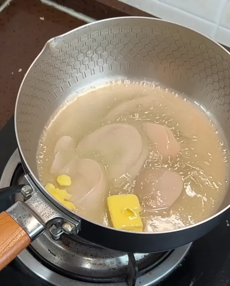 Strisce di pancetta e aglio che friggono in una padella con burro in fusione.