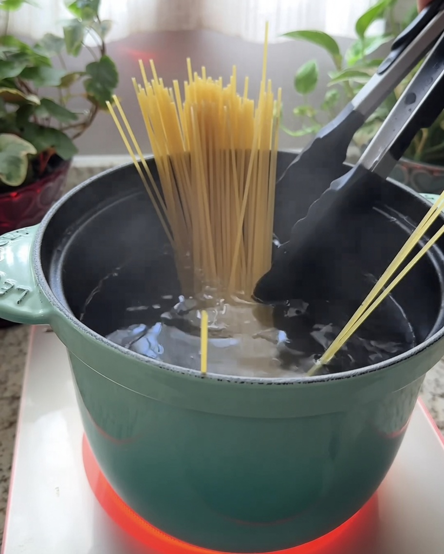 Spaghetti immersi in una pentola dacqua bollente.