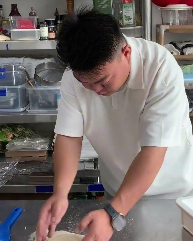 Farina leggermente spolverata su un panetto di impasto crudo su un tavolo in acciaio inox.