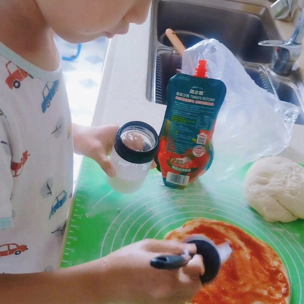 Sale spolverato sulla salsa di pomodoro della pizza.