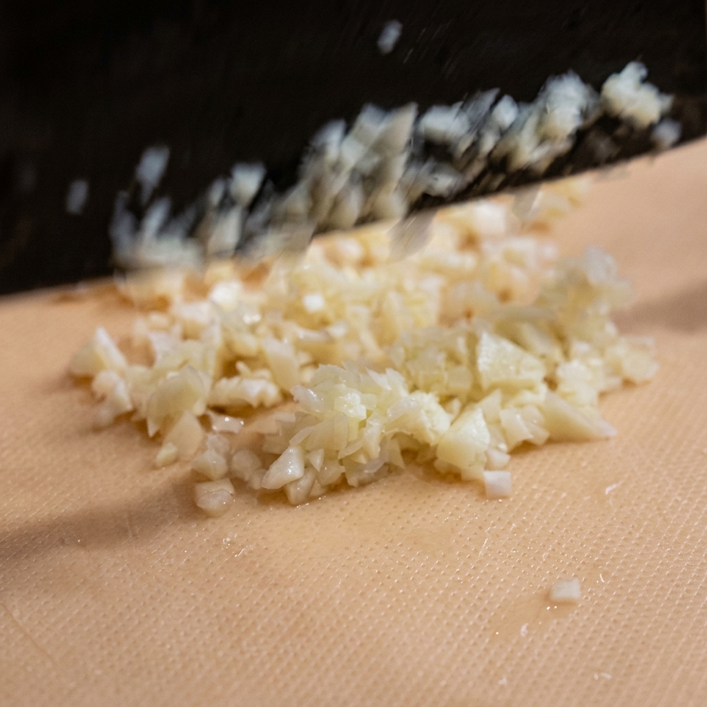 Aglio tritato finemente su un tagliere.