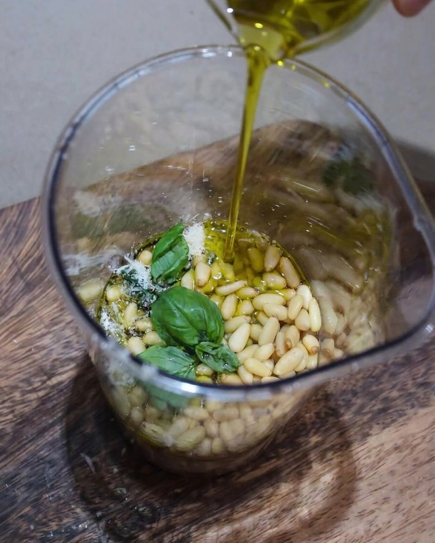 Primo piano della lavorazione del pesto nel contenitore.