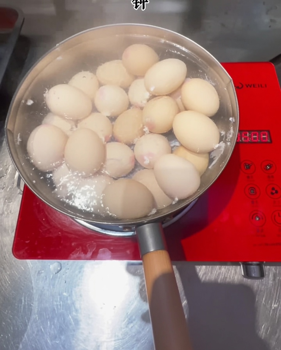 Uova che cuociono in una pentola di acqua bollente su un piano a induzione.