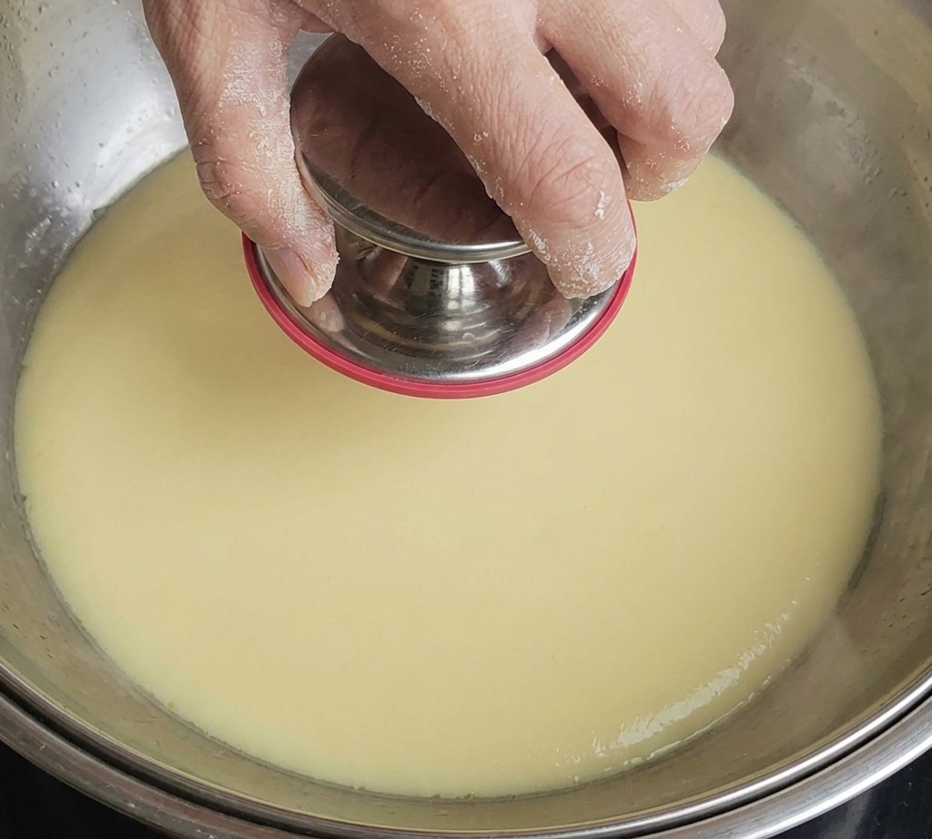Germogli di bambù reidratati che vengono tagliati a pezzetti su un tagliere.