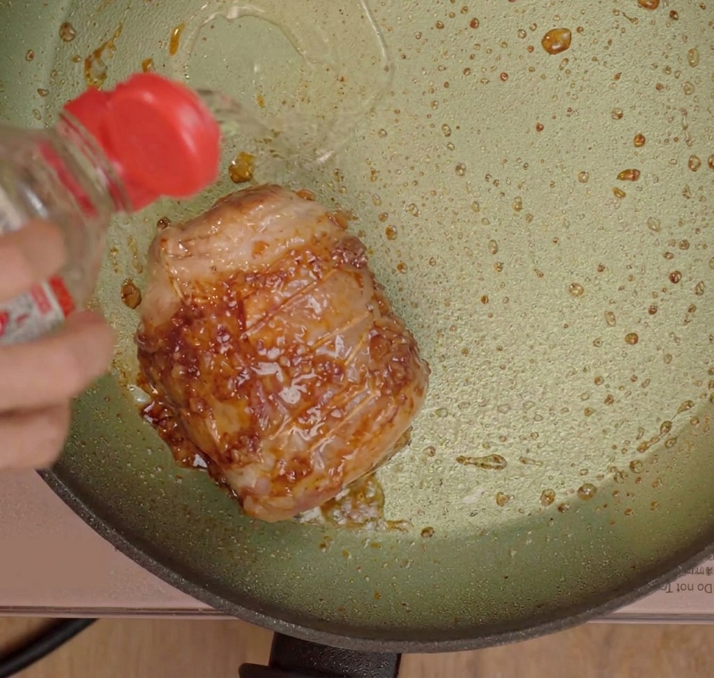 Liquidi di cottura versati sulla pancetta rosolata.