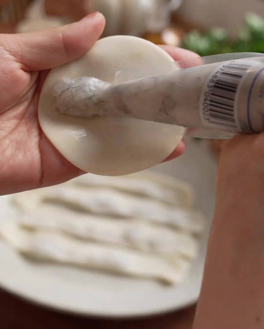 Pasta di gamberi distribuita in una linea dritta al centro del foglio per ravioli.