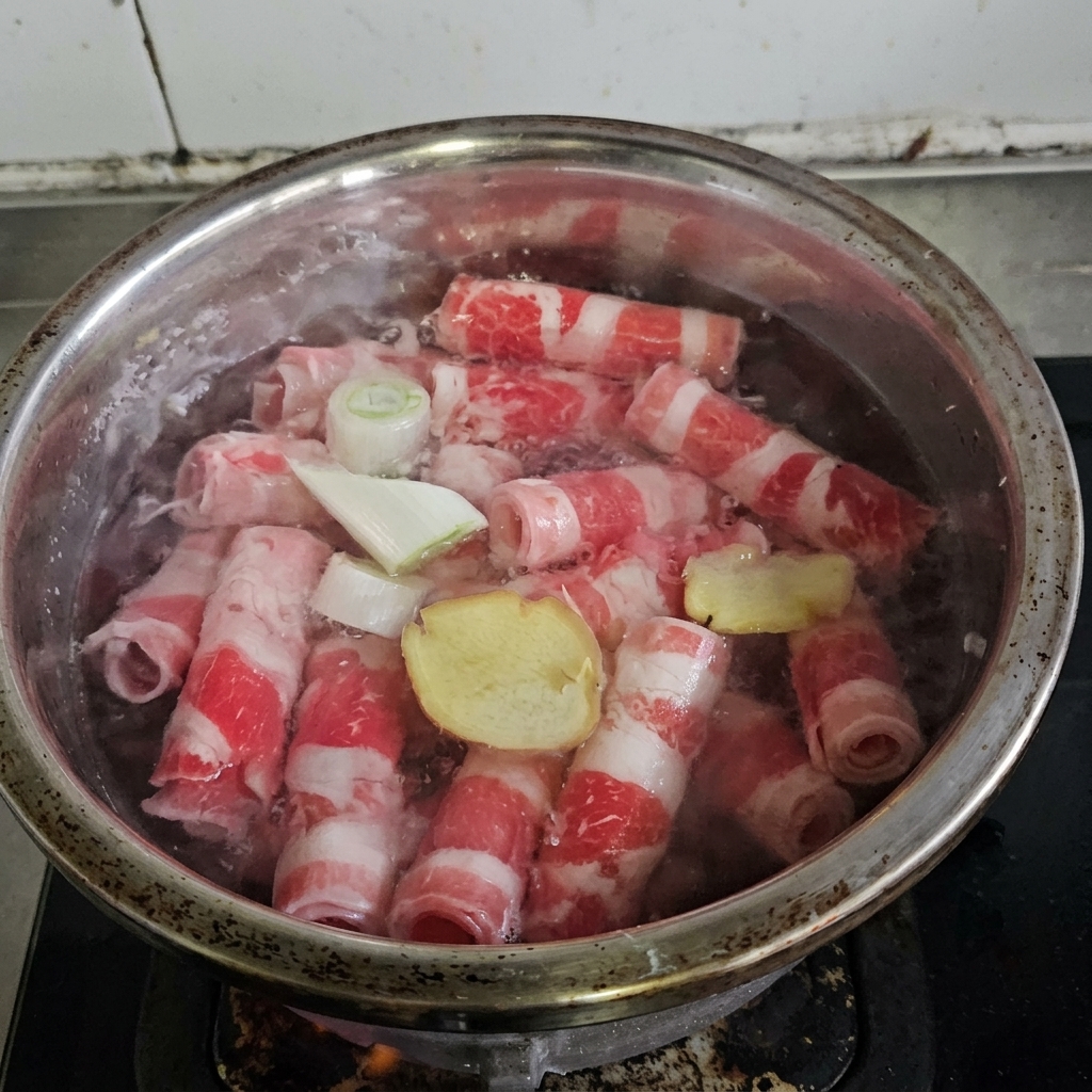 Involtini di manzo che bollono in una pentola con aromi e vino da cucina.