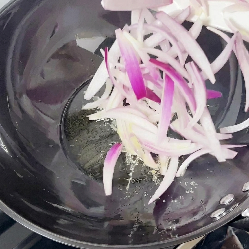 Fettine di cipolla rossa saltate in un wok.