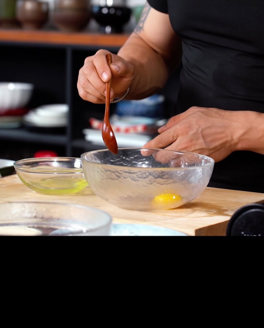 Un tuorlo duovo e acqua fredda in una ciotola di vetro, pronti per essere mescolati con la farina per tempura.