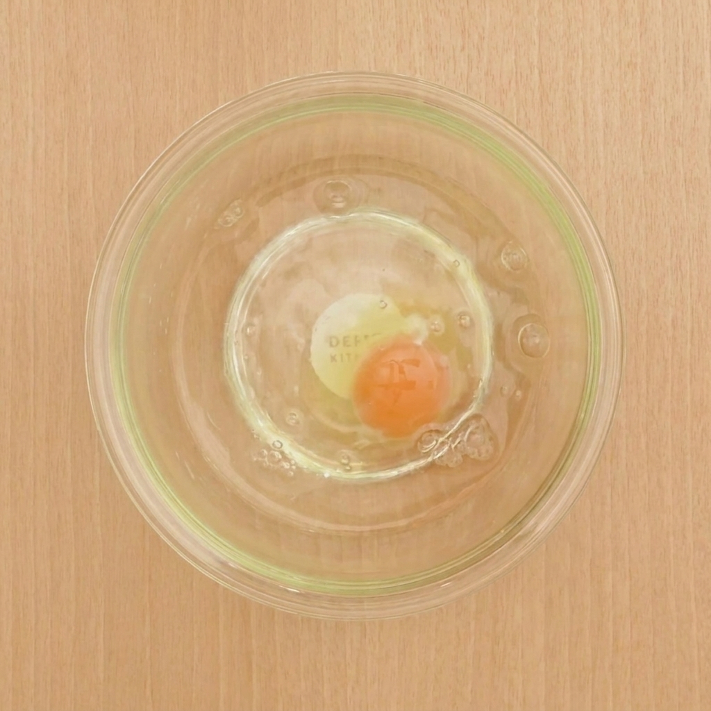 Una ciotola con luovo, lacqua fredda, la farina e la fecola mescolati per creare una pastella liscia.
