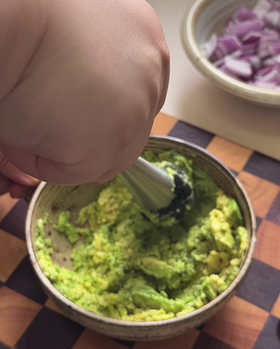 Polpa di avocado schiacciata in purea in una ciotola.