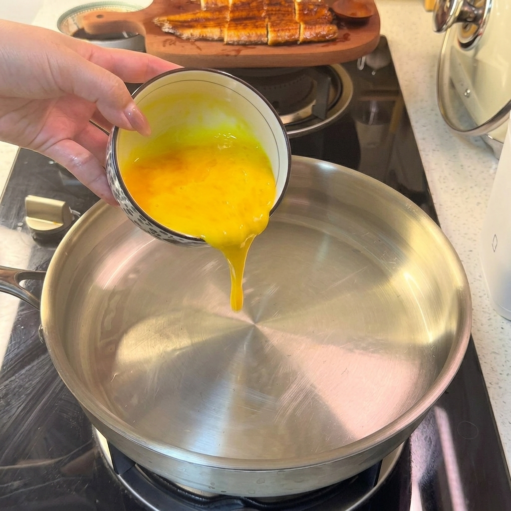 Il composto liquido di uova che colpisce una padella calda, iniziando a solidificarsi in uno strato sottile.