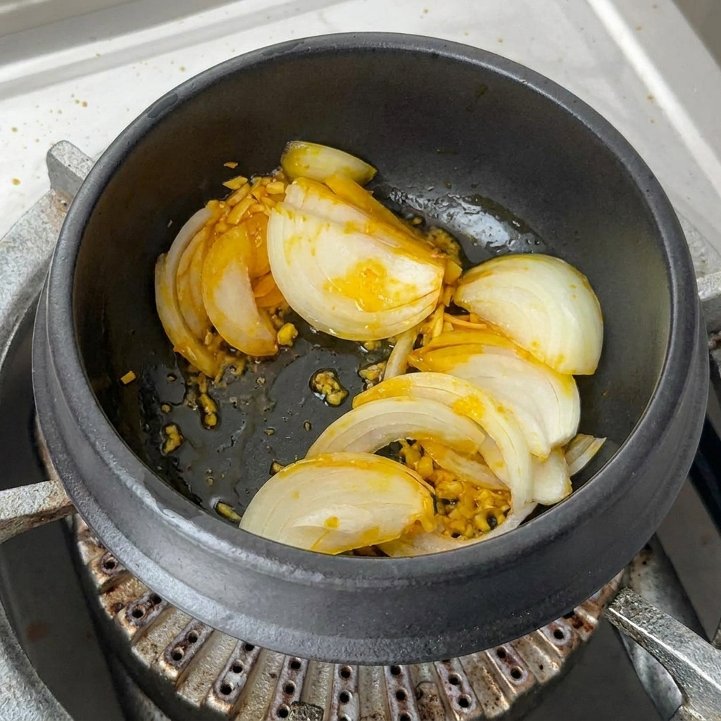 Generose porzioni di kimchi tritato vibrante e fette di peperoncino rosso mescolate nella pentola.