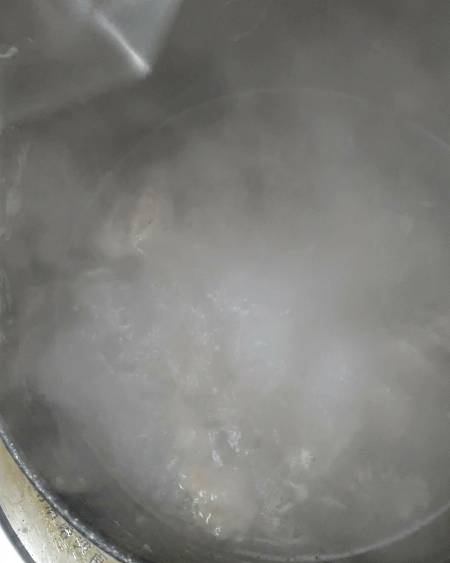Acqua limpida versata in una pentola che sta sobbollendo.