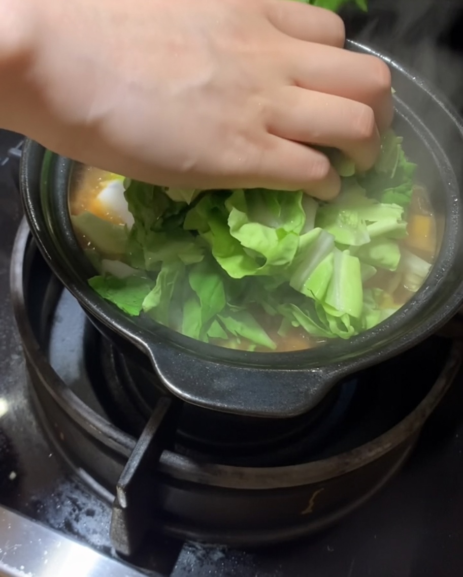 Verdure a foglia fresca aggiunte allo stufato.