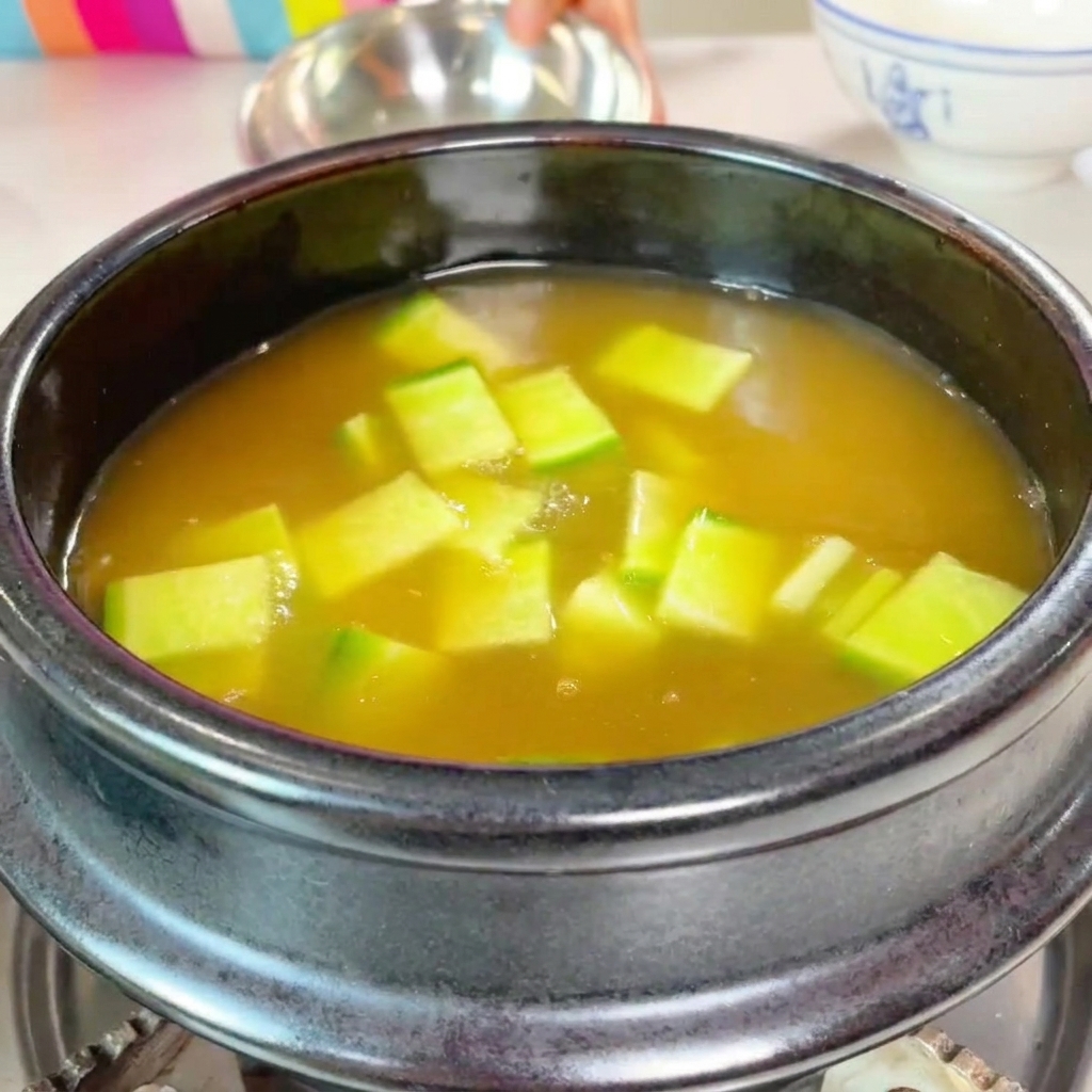 Zucchine a cubetti e funghi affettati aggiunti al tegame.