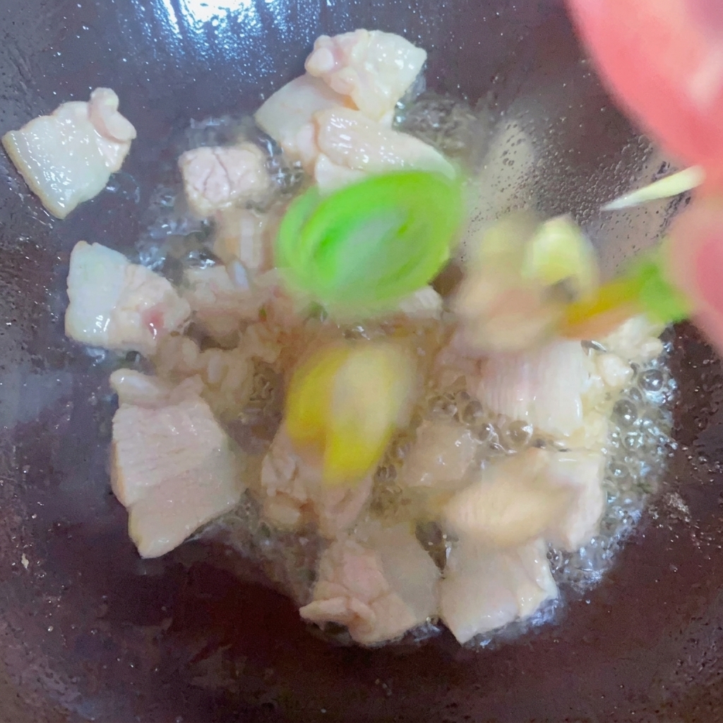 Cipollotti, zenzero e aglio saltati con la pancetta nel wok.