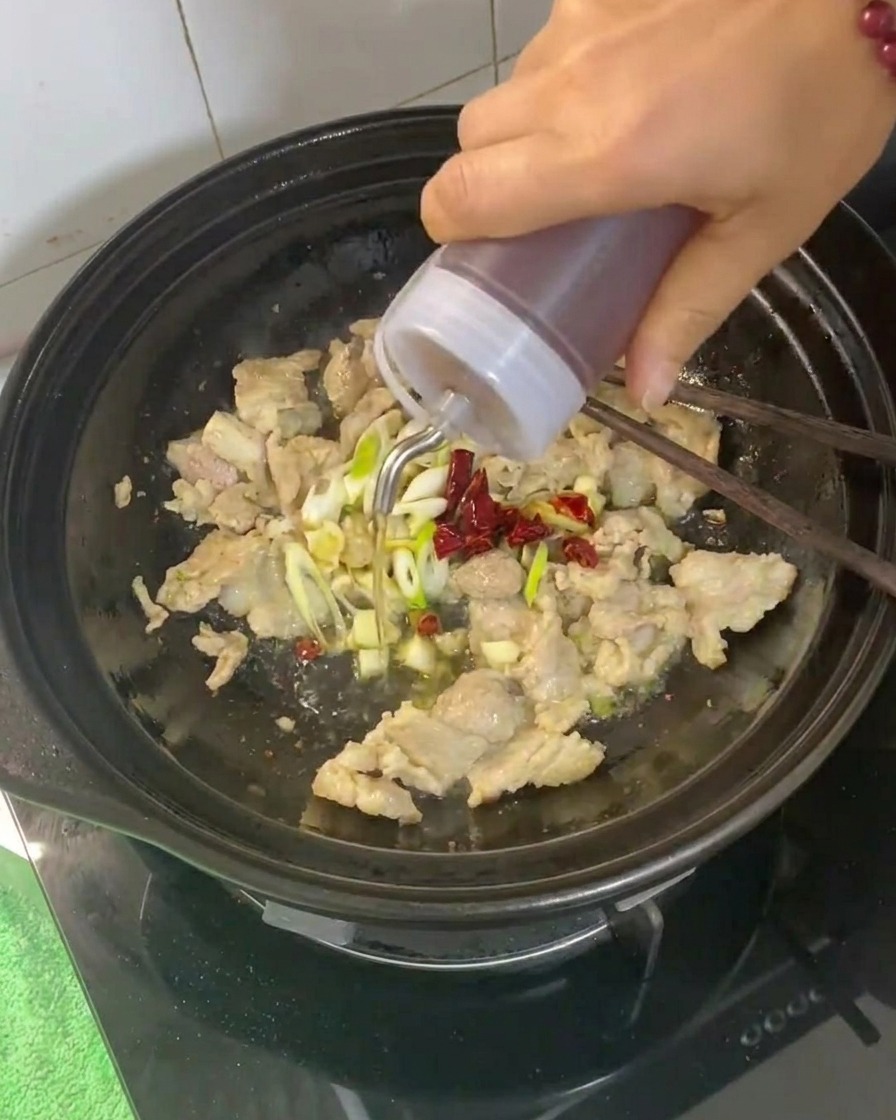 Vino da cucina versato nella pentola di coccio contenente la carne e gli aromi.