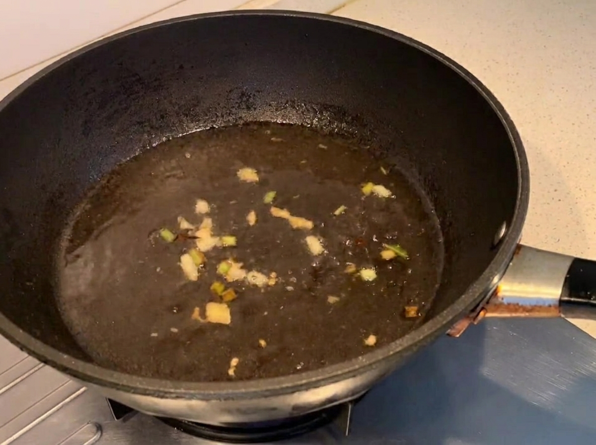 Condimenti mescolati nel liquido bollente in una padella.