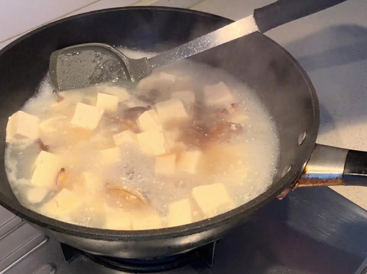 Salsa di soia versata nella zuppa in ebollizione.