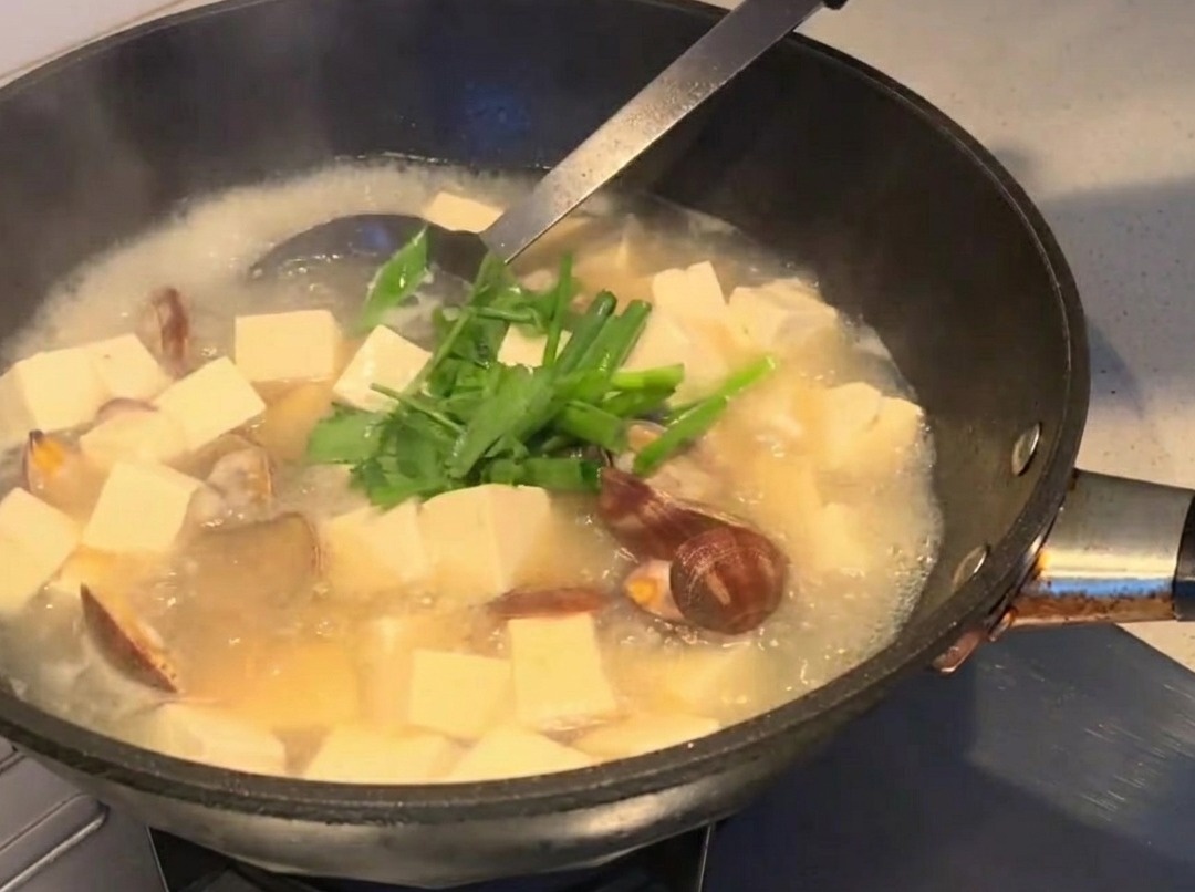 Erbe fresche cosparse sulla zuppa finita.