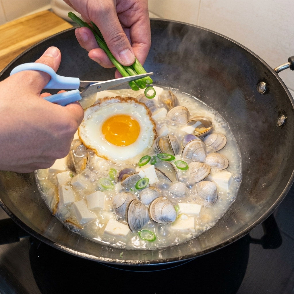 Cipollotti freschi tritati sparsi sulla zuppa bollente.
