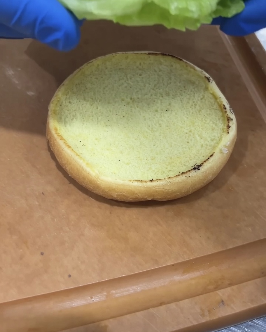 Lattuga fresca e pomodoro a fette posizionati su un panino tostato.