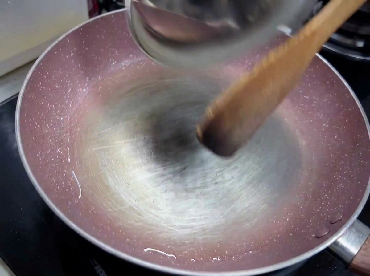 Aglio tritato e cipolla bianca a cubetti che soffriggono in un filo dolio doliva in padella.