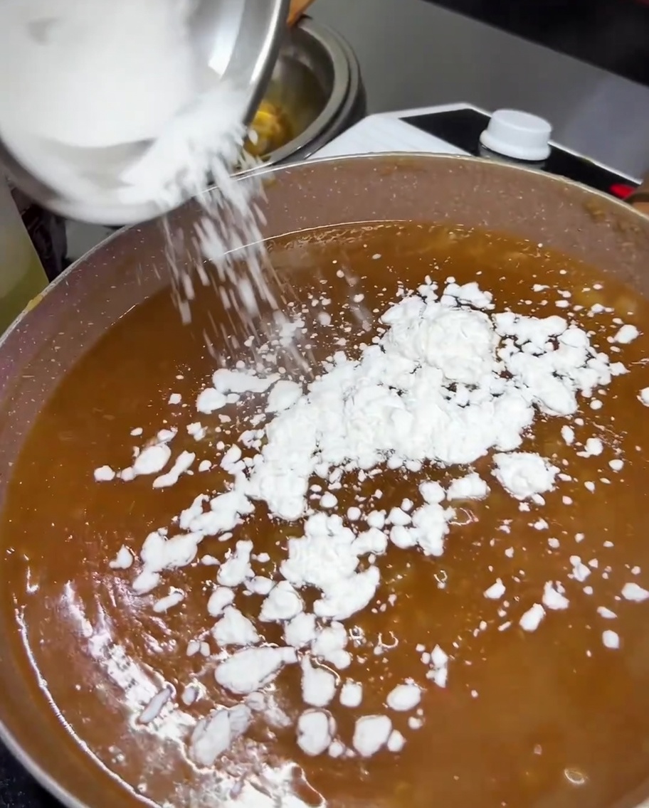 Fecola di tapioca aggiunta alla salsa teriyaki che sobbolle in padella.