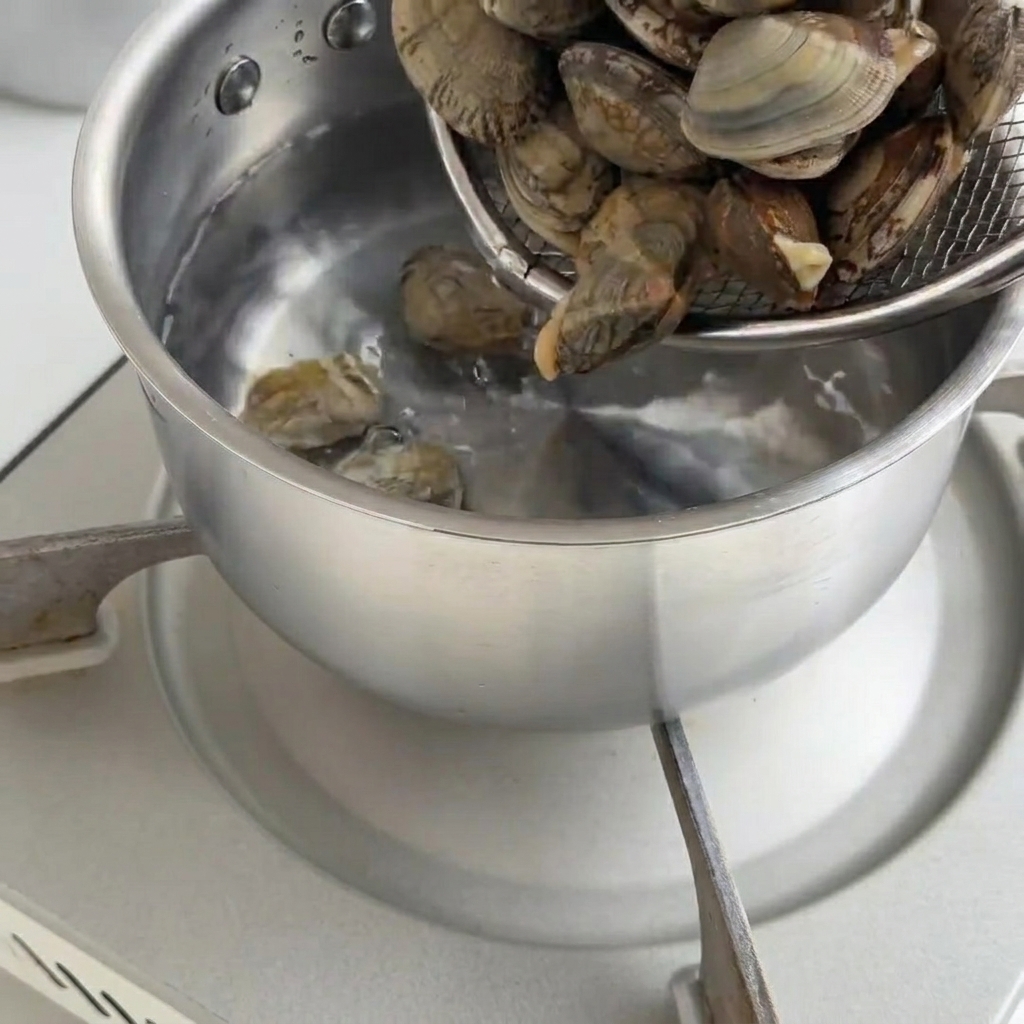 Vongole fresche in una pentola mentre si aprono con il calore.