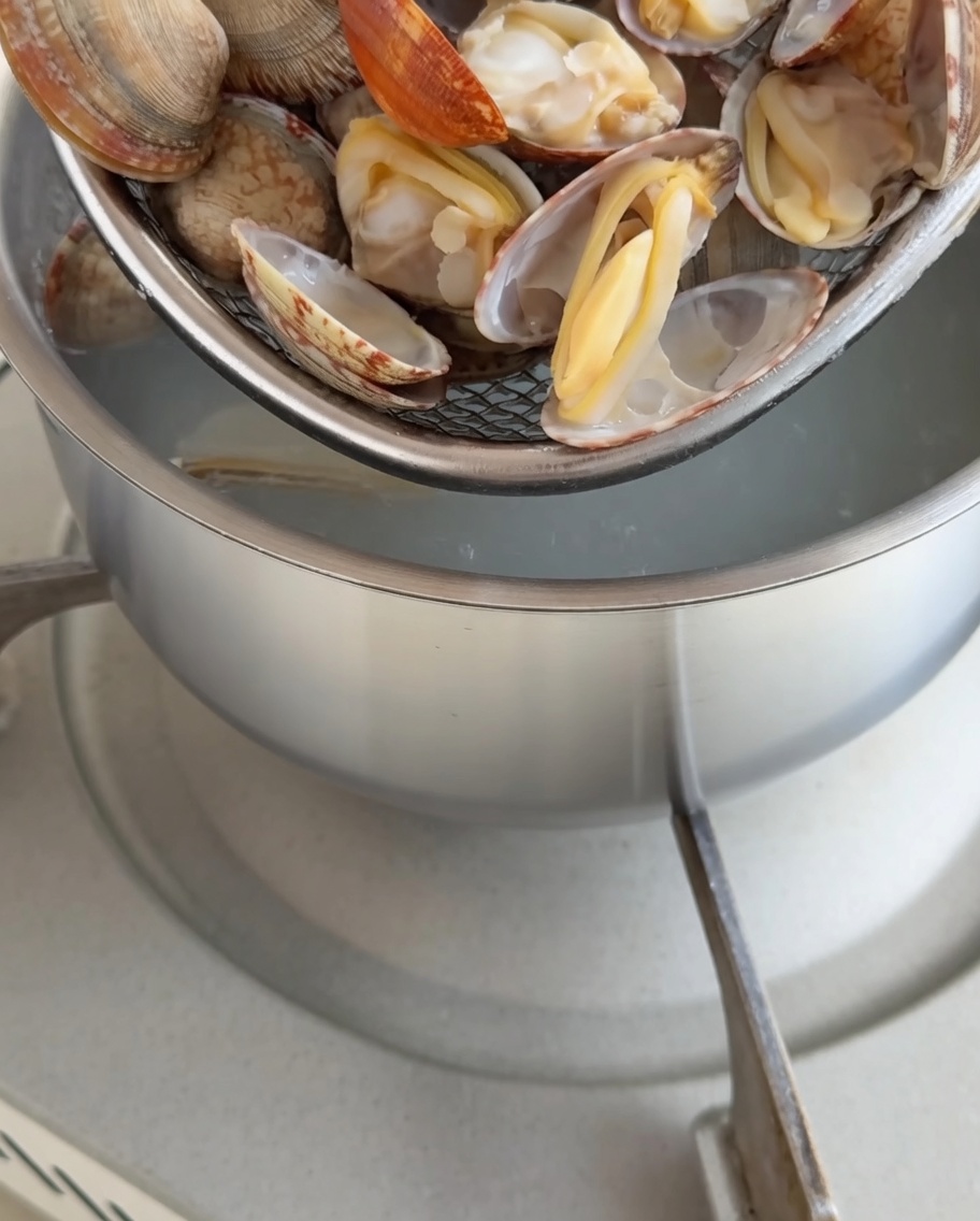 Vongole cotte in un pentolino con la polpa estratta con cura.