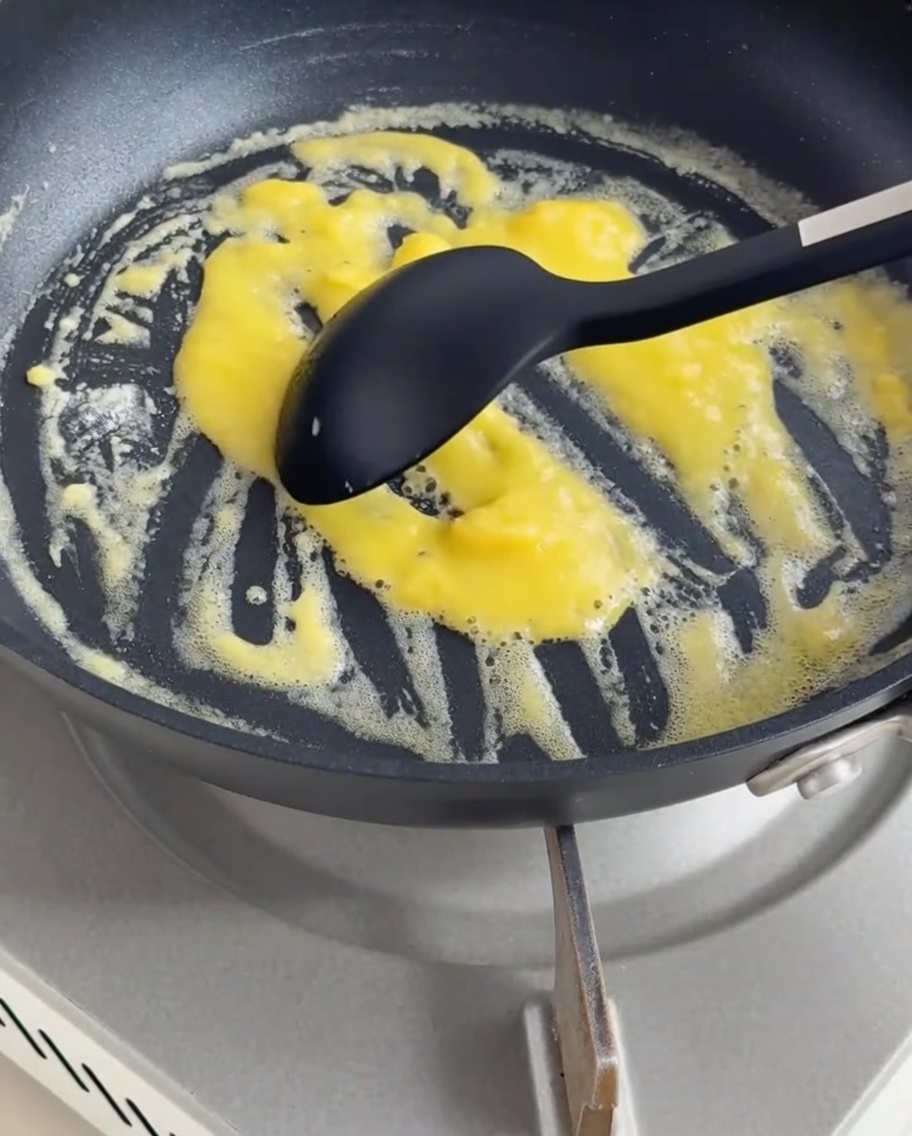Panna e latte versati nel roux, mescolati fino a ottenere una salsa vellutata.