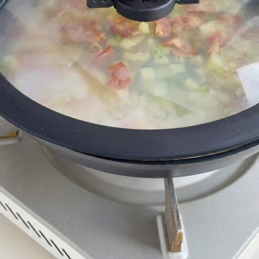 Base della zuppa cremosa che sobbolle con vongole e bacon.