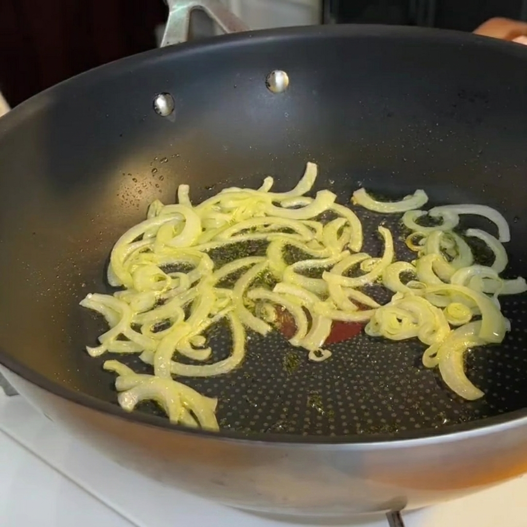Pezzetti di asparagi aggiunti alla padella con la cipolla soffritta.