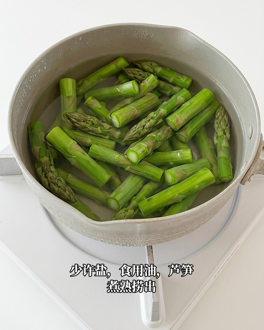 Pezzi di asparagi sbollentati estratti dallacqua bollente con una schiumarola.