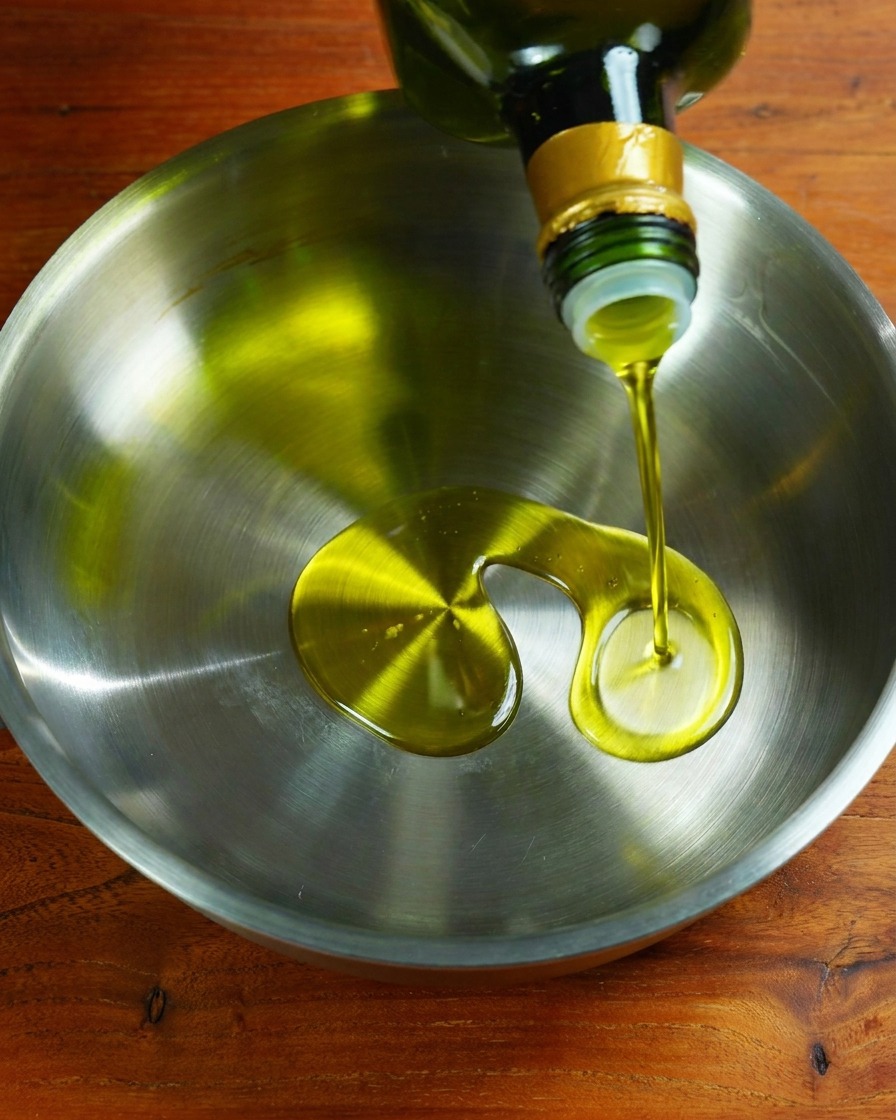 Aglio e cipolla che soffriggono nellolio in una padella.