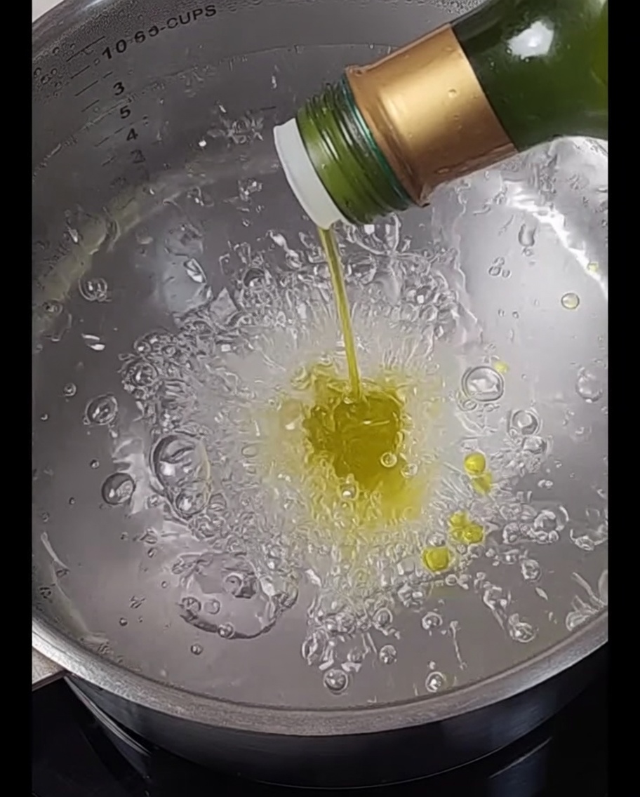Spaghetti immersi in una pentola di acqua bollente.