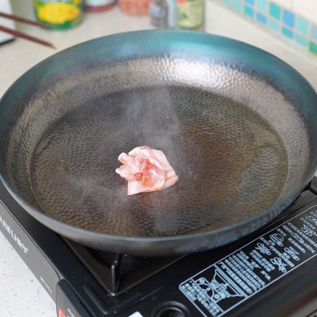 Pezzi di bacon che friggono in una padella calda, diventando croccanti.