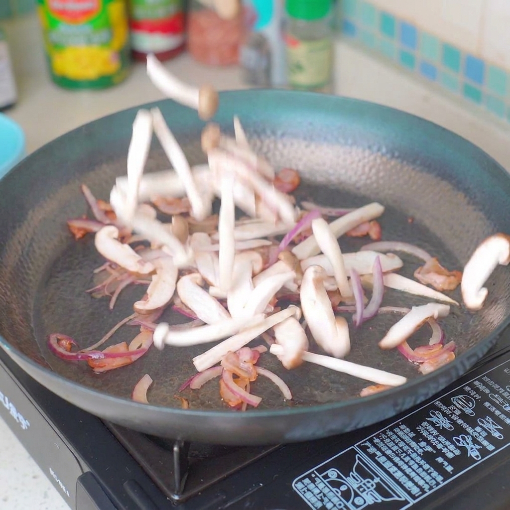 Funghi a fette e cipolla rossa saltati in padella con il bacon.